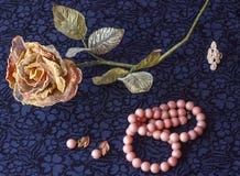 Het stilleven van kunstmatig nam met roze parels, oorringen, broche op textielachtergrond toe royalty-vrije stock afbeelding Het stilleven van kunstmatig nam met roze parels, oorringen, broche op textielachtergrond toe royalty-vrije stock afbeelding