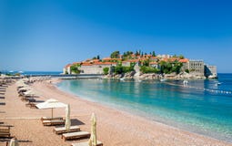 Het strand van het de luxezand van Svetistefan met chaise-longuestoelen en paraplu's royalty-vrije stock afbeeldingen Het strand van het de luxezand van Svetistefan met chaise-longuestoelen en paraplu's royalty-vrije stock afbeeldingen