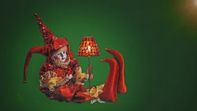 Het stuk speelgoed van clownVenetian in rode kleding op groene achtergrond stock foto Het stuk speelgoed van clownVenetian in rode kleding op groene achtergrond stock foto