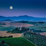 Het toneellandschap van Toscanië met rollende heuvels onder volle maan stock fotografie Het toneellandschap van Toscanië met rollende heuvels onder volle maan stock fotografie