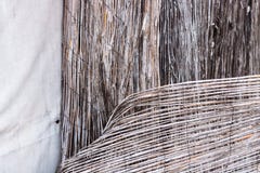 Het uitstekende close-up van de bamboerotan van een dilapidated retro versleten die omheining met geroeste draad en de witte acht royalty-vrije stock fotografie Het uitstekende close-up van de bamboerotan van een dilapidated retro versleten die omheining met geroeste draad en de witte acht royalty-vrije stock fotografie