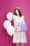 Het verraste meisje in een kleding, en houdt giften in haar handen, op een roze achtergrond, stock foto's Het verraste meisje in een kleding, en houdt giften in haar handen, op een roze achtergrond, stock foto's