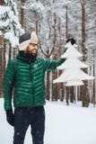 Het verticale portret van dlightful positief gebaard mannetje gekleed in warme de winterkleren, bekijkt met gelukkige uitdrukking stock afbeelding Het verticale portret van dlightful positief gebaard mannetje gekleed in warme de winterkleren, bekijkt met gelukkige uitdrukking stock afbeelding