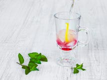 Het voorbereiden van een verfrissende cocktail van mineraalwater, citroen, framboos, munt en ijs stock afbeeldingen Het voorbereiden van een verfrissende cocktail van mineraalwater, citroen, framboos, munt en ijs stock afbeeldingen