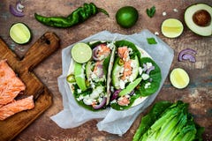 Het voorbereiden van gezonde lunchsnacks Vissentaco's met geroosterde zalm, rode ui, de verse saladebladeren en saus van de avoca stock fotografie Het voorbereiden van gezonde lunchsnacks Vissentaco's met geroosterde zalm, rode ui, de verse saladebladeren en saus van de avoca stock fotografie