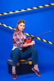 Het vrij sexy arbeidersmeisje chechered overhemd, bouwt beschermende brillen in en je stock foto's Het vrij sexy arbeidersmeisje chechered overhemd, bouwt beschermende brillen in en je stock foto's