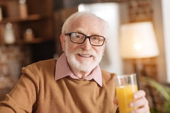 Het vrolijke hogere mens stellen met een glas jus d'orange royalty-vrije stock foto Het vrolijke hogere mens stellen met een glas jus d'orange royalty-vrije stock foto