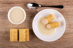 Het wafeltje rolt met condens in schotel, glaskom met melk, lepel op lijst Hoogste mening stock foto's Het wafeltje rolt met condens in schotel, glaskom met melk, lepel op lijst Hoogste mening stock foto's