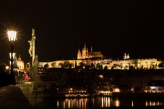 Het Weergeven van het Gotische Kasteel van Praag met Charles Bridge bij nacht, Tsjechische Republiek stock afbeelding Het Weergeven van het Gotische Kasteel van Praag met Charles Bridge bij nacht, Tsjechische Republiek stock afbeelding