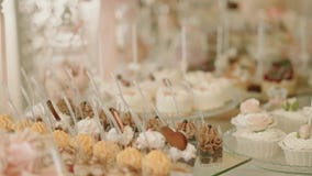Het witte Huwelijk van de Suikergoedbar, huwelijksgebakjes op het zoete buffet van het lijstsuikergoed Sluit omhoog bewegingscame stock footage Het witte Huwelijk van de Suikergoedbar, huwelijksgebakjes op het zoete buffet van het lijstsuikergoed Sluit omhoog bewegingscame stock footage
