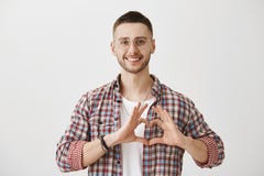 Heureux d'être dans l'amour avec vous Le tir de studio du type ordinaire beau en verres montrant le coeur signent plus de le coff image libre de droits Heureux d'être dans l'amour avec vous Le tir de studio du type ordinaire beau en verres montrant le coeur signent plus de le coff image libre de droits
