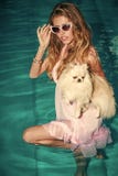 High fashion portrait of elegant woman. Sensual woman with cute spitz puppy in blue water royalty free stock photo High fashion portrait of elegant woman. Sensual woman with cute spitz puppy in blue water royalty free stock photo