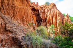 High red clay rocks and cliffs washed by winter rains and surface water flows. Clay quarry, mines landscape scene in Cilento and