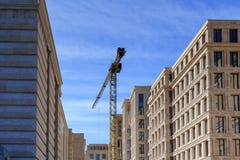 High-rise kraan op de achtergrond van huizen in aanbouw Stock Afbeeldingen High-rise kraan op de achtergrond van huizen in aanbouw Stock Afbeeldingen