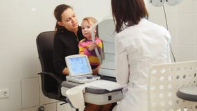 High tehnology in healthcare - optometrist in clinic checking little girl`s vision - children`s ophthalmology stock image High tehnology in healthcare - optometrist in clinic checking little girl`s vision - children`s ophthalmology stock image