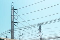 High voltage cables for electricity transmission over roof on blue sky background stock photo High voltage cables for electricity transmission over roof on blue sky background stock photo