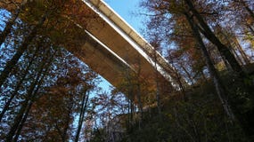 Highway overpass crossing Kamacnik canyon, towering high above wonderful forest during autumn season in Croatian mountains