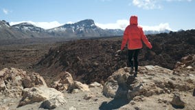 Hihg молодой женщины идя в горах и наблюдать огромным кратером вулкана Teide в Тенерифе, Канарских островах, Испании сток-видео Hihg молодой женщины идя в горах и наблюдать огромным кратером вулкана Teide в Тенерифе, Канарских островах, Испании сток-видео