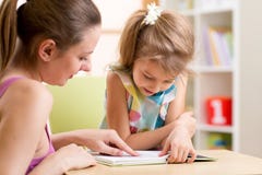Hija de enseñanza del niño de la madre a leer imagen de archivo libre de regalías Hija de enseñanza del niño de la madre a leer imagen de archivo libre de regalías