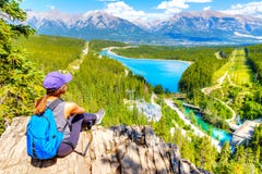 Staycation hiker on top of mountain overlooking local town of Canmore and Kananaskis