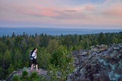 Hiker дамы при рюкзак двигая к верхней части горы на заходе солнца стоковые фотографии rf Hiker дамы при рюкзак двигая к верхней части горы на заходе солнца стоковые фотографии rf