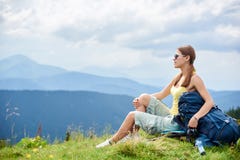 Hiker женщины на травянистом холме, нося рюкзаке, используя trekking ручки в горах стоковые фотографии rf Hiker женщины на травянистом холме, нося рюкзаке, используя trekking ручки в горах стоковые фотографии rf