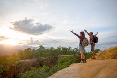 Hikers with backpacks relaxing on top of a mountain and enjoying stock photos Hikers with backpacks relaxing on top of a mountain and enjoying stock photos