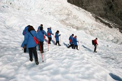 Hikers в наклоне отдельного файла нисходящем ледистом на исследование ледника стоковые изображения rf Hikers в наклоне отдельного файла нисходящем ледистом на исследование ледника стоковые изображения rf
