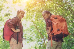 Hikers с рюкзаками идя через луг с сочной травой Молодой азиатский женский хипстер 2 на празднике горы стоковые фотографии rf Hikers с рюкзаками идя через луг с сочной травой Молодой азиатский женский хипстер 2 на празднике горы стоковые фотографии rf