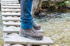 Hiking boots on tree trunk bridge over a creek stock photography Hiking boots on tree trunk bridge over a creek stock photography