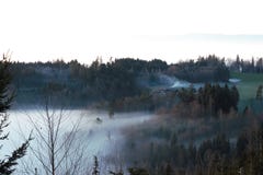Hills and forest and a farmhouse just above the fog stock photo Hills and forest and a farmhouse just above the fog stock photo