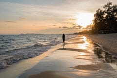 himmel-und-meer-bei-sonnenuntergang-schattenbild-der-jungen-frau-gehend-auf-ozeanstrand-90699748.jpg