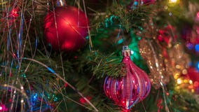 Hingen de helder gekleurde, vrolijke Kerstboomornamenten omhoog met lichten en klatergoud stock fotografie Hingen de helder gekleurde, vrolijke Kerstboomornamenten omhoog met lichten en klatergoud stock fotografie