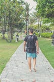 Hintere Ansicht des Mannes mit Rucksack gehend in den Strandpark von Nusa-DUA, Bali-Insel, Indonesien Lizenzfreie Stockfotos Hintere Ansicht des Mannes mit Rucksack gehend in den Strandpark von Nusa-DUA, Bali-Insel, Indonesien Lizenzfreie Stockfotos