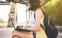 Hipster Asian Woman Tourist Using Internet With Laptop Computer And Waiting Train At Train Station,Travel And Vacation Concept Royalty Free Stock Images