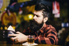 Hipster holds wallet, counting money to buy drinks. Depression and alcoholism concept. Guy spend leisure in bar royalty free stock photography Hipster holds wallet, counting money to buy drinks. Depression and alcoholism concept. Guy spend leisure in bar royalty free stock photography