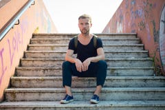 Hipster modern stylish blonde man sitting in stairs Royalty Free Stock Photography Hipster modern stylish blonde man sitting in stairs Royalty Free Stock Photography