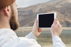 Hipster person holding in hands digital tablet with empty blank screen, man photograph on computer on background nature Stock Image Hipster person holding in hands digital tablet with empty blank screen, man photograph on computer on background nature Stock Image