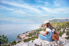Hipster young girl with bright backpack enjoying panoramic mountain sea, using map and looking distance stock image Hipster young girl with bright backpack enjoying panoramic mountain sea, using map and looking distance stock image