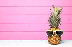 Hipsterananas med solglasögon mot rosa trä arkivfoto Hipsterananas med solglasögon mot rosa trä arkivfoto