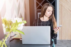 Hipsterflicka som pratar på mobiltelefonen, når att ha använt netto-boken royaltyfri fotografi Hipsterflicka som pratar på mobiltelefonen, når att ha använt netto-boken royaltyfri fotografi