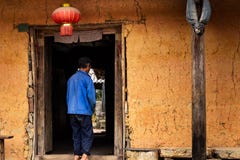 Unrecognisable hmong farmer entering a traditional hmong house with a chinese lantern hanging in Ha Giang Province, Vietnam royalty free stock photos Unrecognisable hmong farmer entering a traditional hmong house with a chinese lantern hanging in Ha Giang Province, Vietnam royalty free stock photos