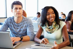 Hochschulstudenten, die Digital-Tablet und -laptop in der Klasse verwenden lizenzfreie stockbilder Hochschulstudenten, die Digital-Tablet und -laptop in der Klasse verwenden lizenzfreie stockbilder