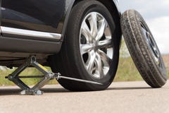 Hochwinden herauf ein Auto, zum eines Reifens zu ändern lizenzfreie stockbilder Hochwinden herauf ein Auto, zum eines Reifens zu ändern lizenzfreie stockbilder
