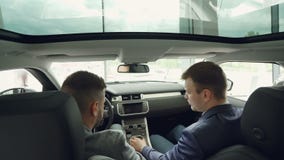 Hoge hoekmening van de arbeider van het autohandel drijven het spreken aan cliëntzitting binnen commerciële klassenauto, wat betr stock footage Hoge hoekmening van de arbeider van het autohandel drijven het spreken aan cliëntzitting binnen commerciële klassenauto, wat betr stock footage