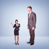 Hoge zakenman die neer weinig vrouw bekijken royalty-vrije stock afbeeldingen Hoge zakenman die neer weinig vrouw bekijken royalty-vrije stock afbeeldingen