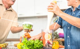 Hoger paar die pret in keuken met gezond veggie voedsel hebben stock fotografie Hoger paar die pret in keuken met gezond veggie voedsel hebben stock fotografie