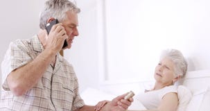 Hogere mens op de pillen van de telefoongesprekholding stock video Hogere mens op de pillen van de telefoongesprekholding stock video