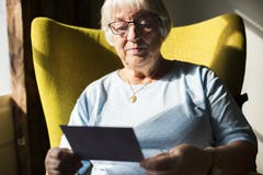 Hogere vrouw die een foto bekijken stock foto's Hogere vrouw die een foto bekijken stock foto's