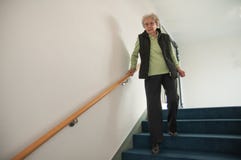 Hogere vrouw die onderaan de treden lopen stock afbeelding Hogere vrouw die onderaan de treden lopen stock afbeelding